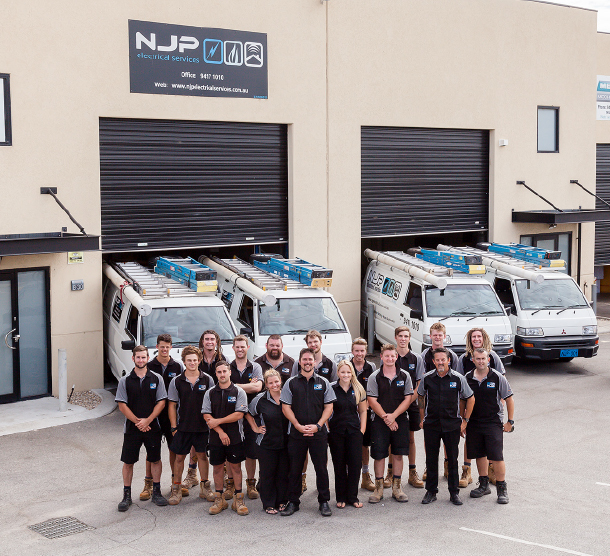 The NJP team stands outside in a carpark
